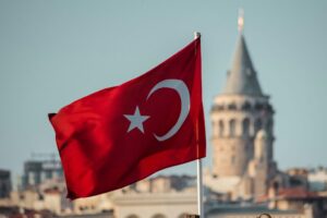 Turkish flag waving with Galata Tower in the background, symbolizing Turkey’s 5G spectrum auction 2025 and digital transformation
