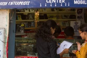 Customers at a mobile phone service centre in Bengaluru